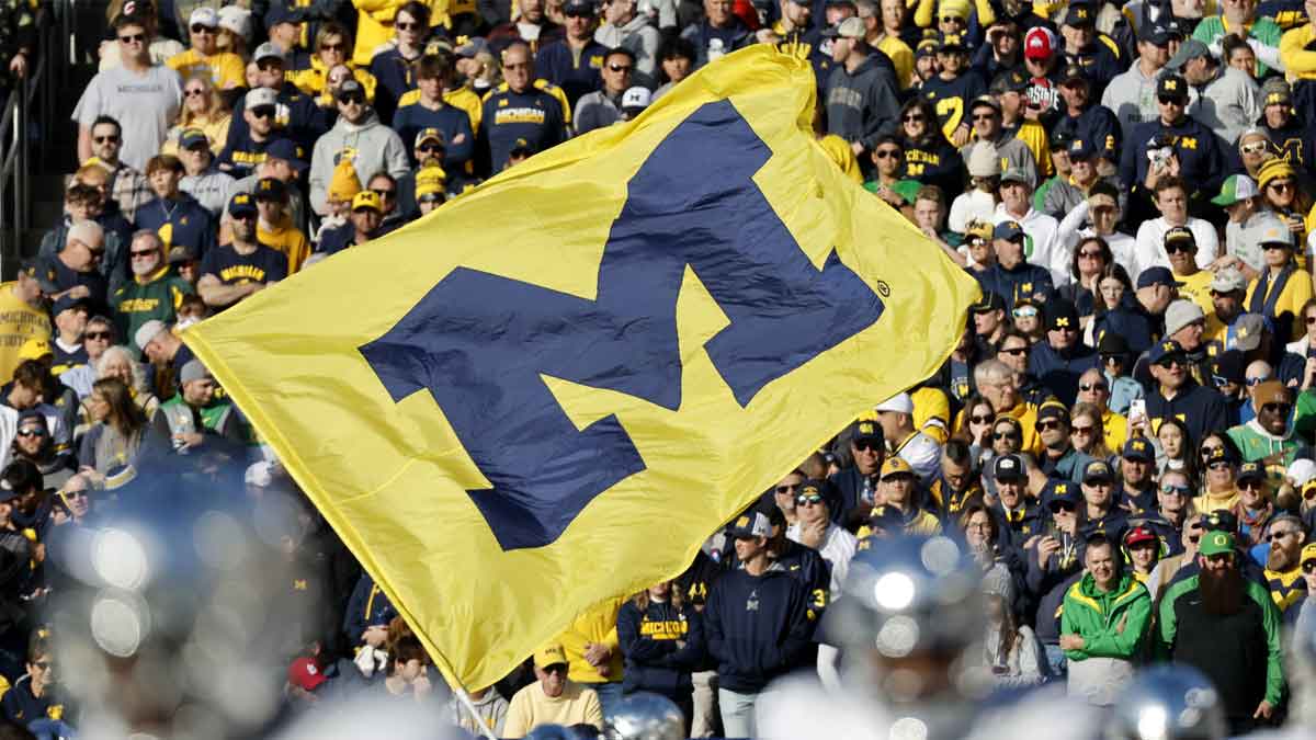 Michigan Wolverines cheerleader runs with a flag before the game against the Oregon Ducks at Michigan Stadium.