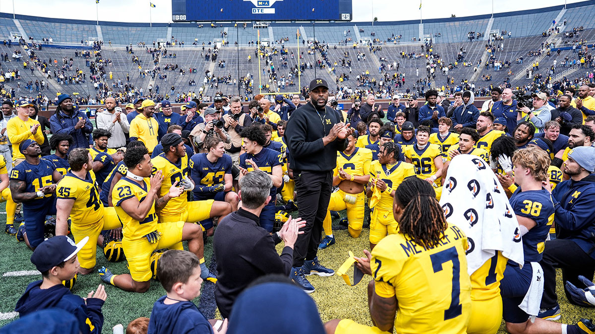 Michigan head coach Sherrone Moore, center, speaks to players after the spring game at Michigan Stadium