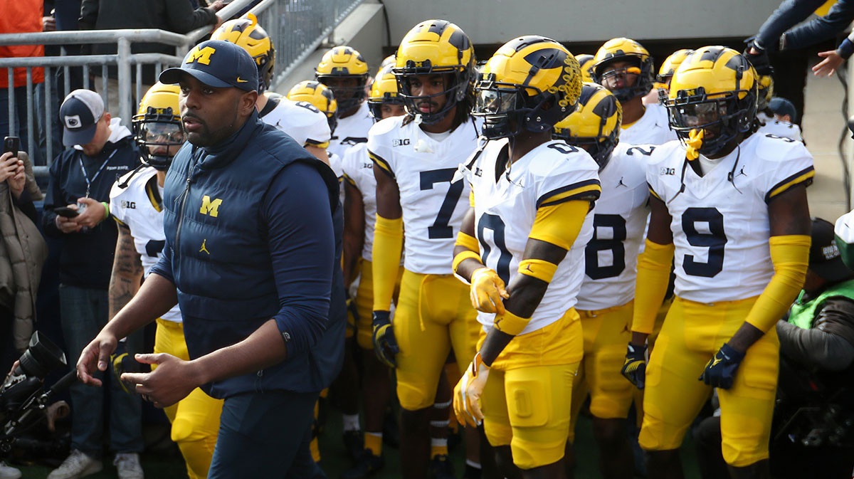 Michigan Wolverines offensive lines coach Sherrone Moore leads the team onto the field before a game against the Penn State Nittany Lions at Beaver Stadium.