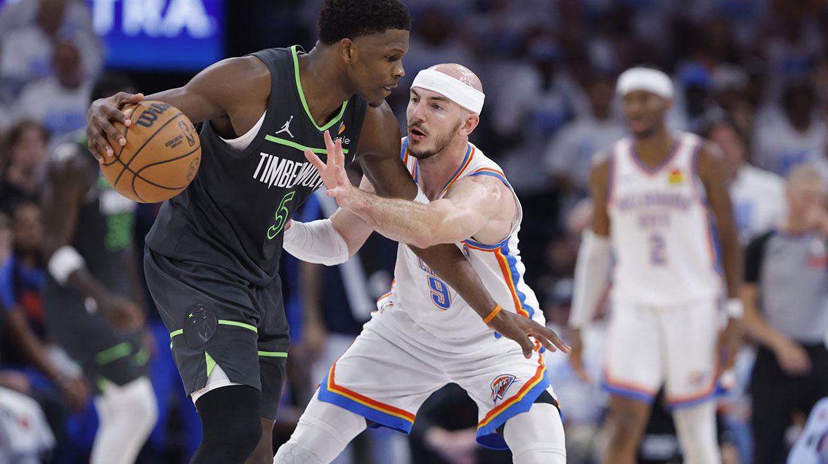 Minnesota Timberwolves guard Anthony Edwards (5) dribbles against Oklahoma City Thunder guard Alex Caruso (9) in the fourth quarter during game one of the western conference finals for the 2025 NBA Playoffs at Paycom Center.