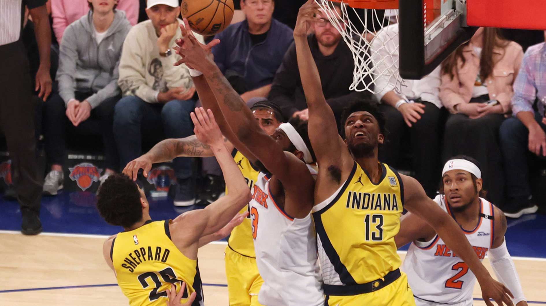 New York Knicks center Mitchell Robinson (23) reaches for the rebound against Indiana Pacers guard Ben Sheppard (26) and center Tony Bradley (13) in the first quarter during game five of the eastern conference finals for the 2025 NBA Playoffs at Madison Square Garden.