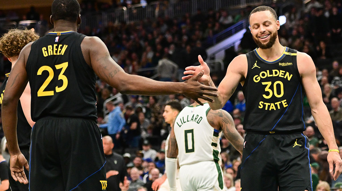Golden State Warriors guard Stephen Curry (30) celebrates with forward Draymond Green (23) in the fourth quarter against the Milwaukee Bucks at Fiserv Forum.