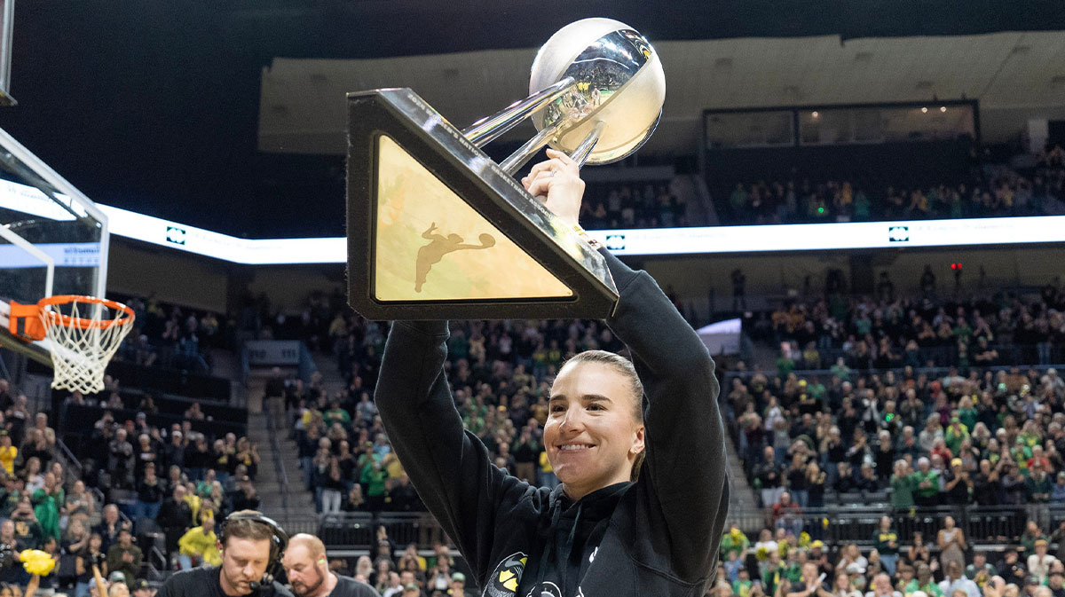 New York Liberty Guard Sabrina Ionescu hold the Women's National Basketball Association Championship trophy over her head during the Oregon women's basketball game against Baylor on Nov. 10, 2024, at Matthew Knight Arena in Eugene. Mandatory Credit: © Chris Pietsch/The Register-Guard / USA TODAY NETWORK via Imagn Images