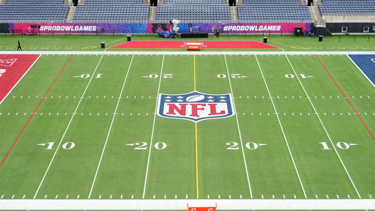 An overall view of the NFL shield logo at midfield on the Camping World Stadium flag football field.