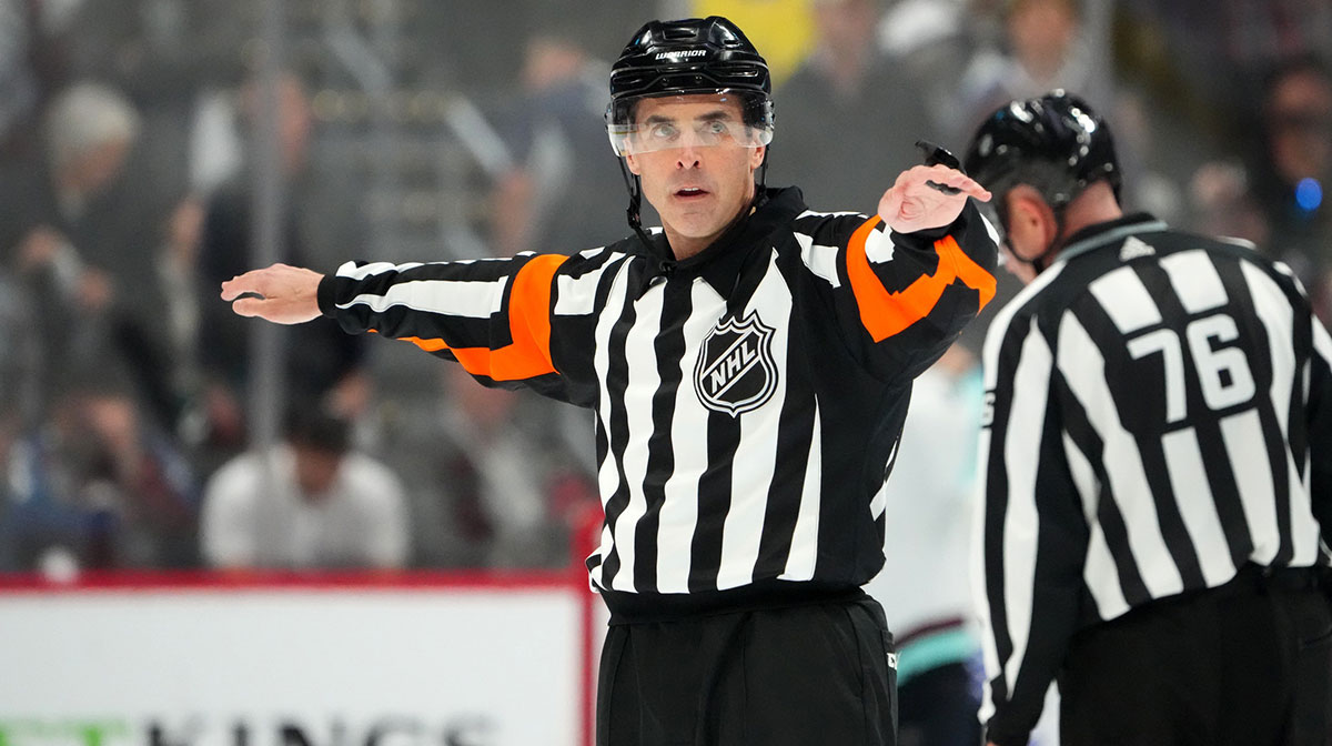 NHL referee Chris Rooney (5) calls a reversal of a goal by Colorado Avalanche center Nathan MacKinnon (29) (not pictured) in the third period against the Seattle Kraken in game seven of the first round of the 2023 Stanley Cup Playoffs at Ball Arena.