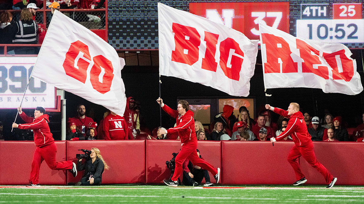 Nebraska Cornhuskers cheerleaders carry flags across the field after a score against the Wisconsin Badgers during the fourth quarter at Memorial Stadium.