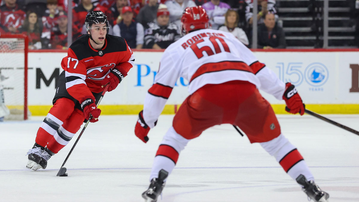 New Jersey Devils defenseman Simon Nemec (17) skates with the puck as Carolina Hurricanes left wing Eric Robinson (50) defends during the first overtime in game three of the first round of the 2025 Stanley Cup Playoffs at Prudential Center.
