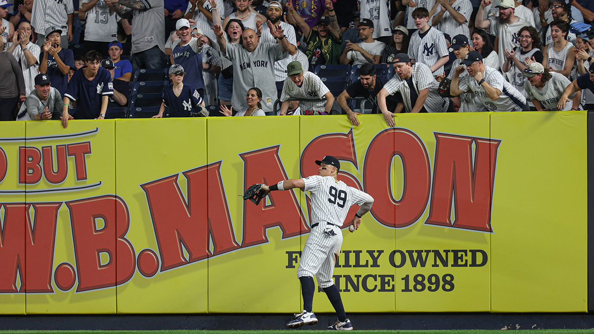 New York Yankees right fielder Aaron Judge (99) throws the ball after making a catch for an out as fans cheer during the ninth inning against the Tampa Bay Rays at Yankee Stadium.