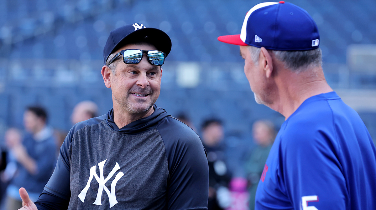 New York Yankees manager Aaron Boone (17) talks to Texas Rangers manager Bruce Bochy (15) before a game at Yankee Stadium.