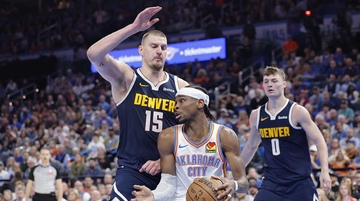 Denver Nuggets center Nikola Jokic (15) defends a drive by Oklahoma City Thunder guard Shai Gilgeous-Alexander (2) during the second half at Paycom Center.