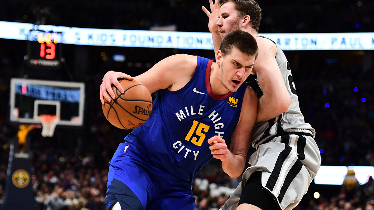 Denver Nuggets center Nikola Jokic (15) drives by San Antonio Spurs center Jakob Poeltl (25) in the second quarter in the first round of the 2019 NBA Playoffs at Pepsi Center.