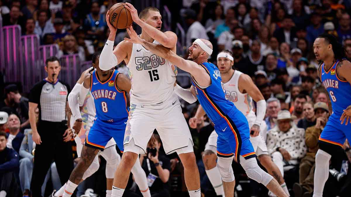 Denver Nuggets center Nikola Jokic (15) controls the ball under pressure form Oklahoma City Thunder guard Alex Caruso (9) in the second quarter during game six of the second round for the 2025 NBA Playoffs at Ball Arena.