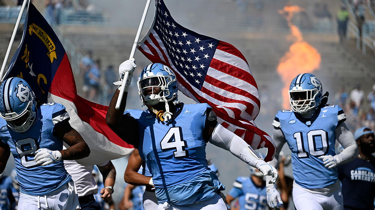North Carolina Tar Heels defensive lineman Travis Shaw (4) runs on to the field with the american flag before the game at Kenan Memorial Stadium.