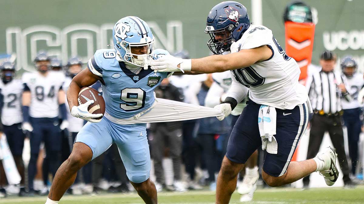 UConn's Pryce Yates tackles North Carolina's Javarius Green during the third annual Wasabi Fenway Bowl at Fenway Park on Saturday, Dec. 28, 2024.