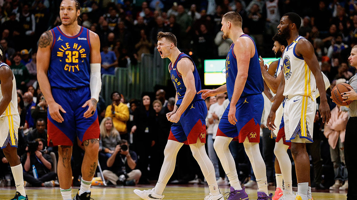 Denver Nuggets guard Christian Braun (0) reacts after a play as center Nikola Jokic (15) and forward Aaron Gordon (32) and Golden State Warriors forward Andrew Wiggins (22) look on in the fourth quarter at Ball Arena.