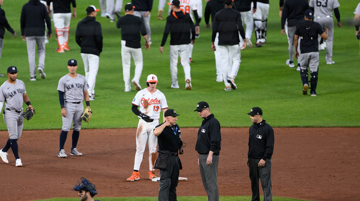 Umpire Lance Barksdale (23), umpire Will Little (93) and umpire Ryan Wills talk as New York Yankees and Baltimore Orioles players run on the infield during the fourth inning at Oriole Park at Camden Yards.