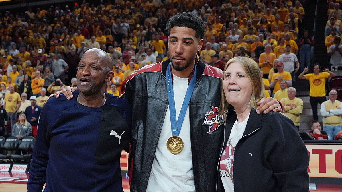 Pacers guard Tyrese Haliburton holds his parents John and Brenda Haliburton as the unveiling his Olympic 24 gold made banner