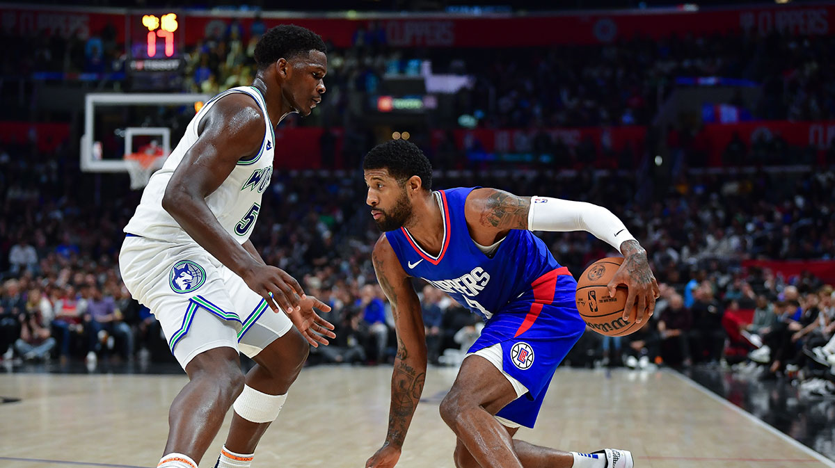 Los Angeles Clippers forward Paul George (13) moves the ball against Minnesota Timberwolves guard Anthony Edwards (5) during the second half at Crypto.com Arena.