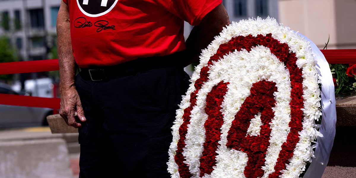 A fan stands next to the Pete Rose statue outside Great American Ball Park during the Cincinnati Red’s Pete Rose night.