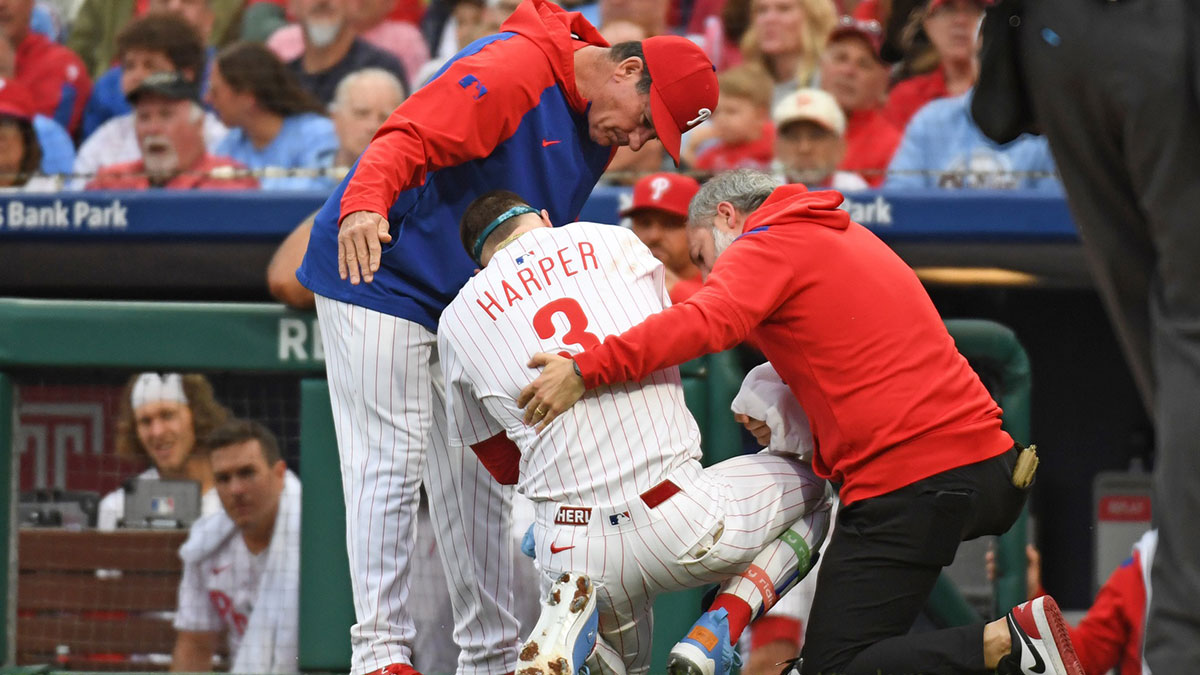 Philadelphia Phillies first base Bryce Harper (3) is looked at by Philadelphia Phillies manager Rob Thomson (59) and trainer Joe Rauch after being hit by a pitch during the first inning against the Atlanta Braves at Citizens Bank Park.