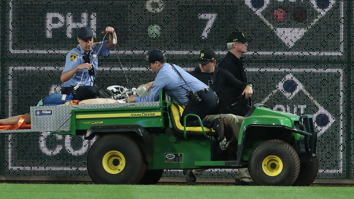 Stadium security and Pittsburgh Pirates medical personnel cart a fan who fell from the stands to the field to an ambulance as the Pirates batted against the Chicago Cubs during the seventh inning at PNC Park.