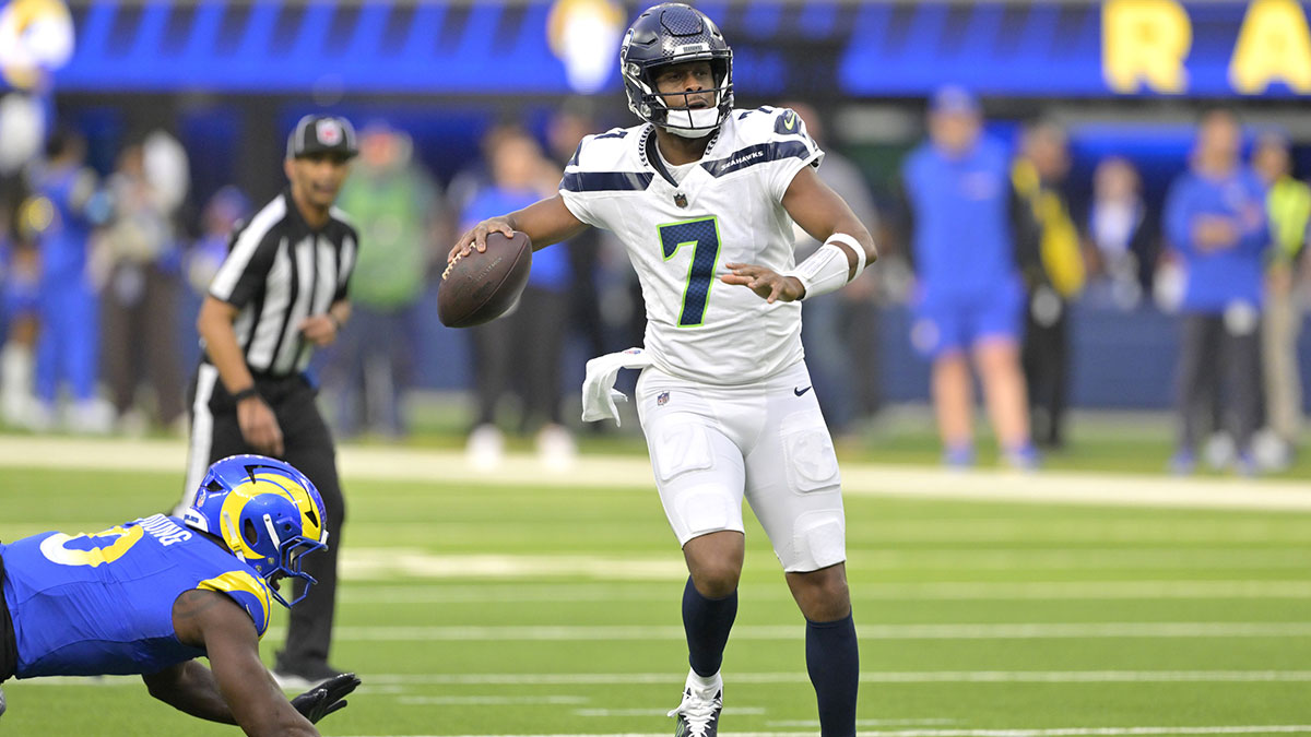 Seattle Seahawks quarterback Geno Smith (7) scrambles away from Los Angeles Rams linebacker Byron Young (0) and throws for a touchdown in the first half at SoFi Stadium.