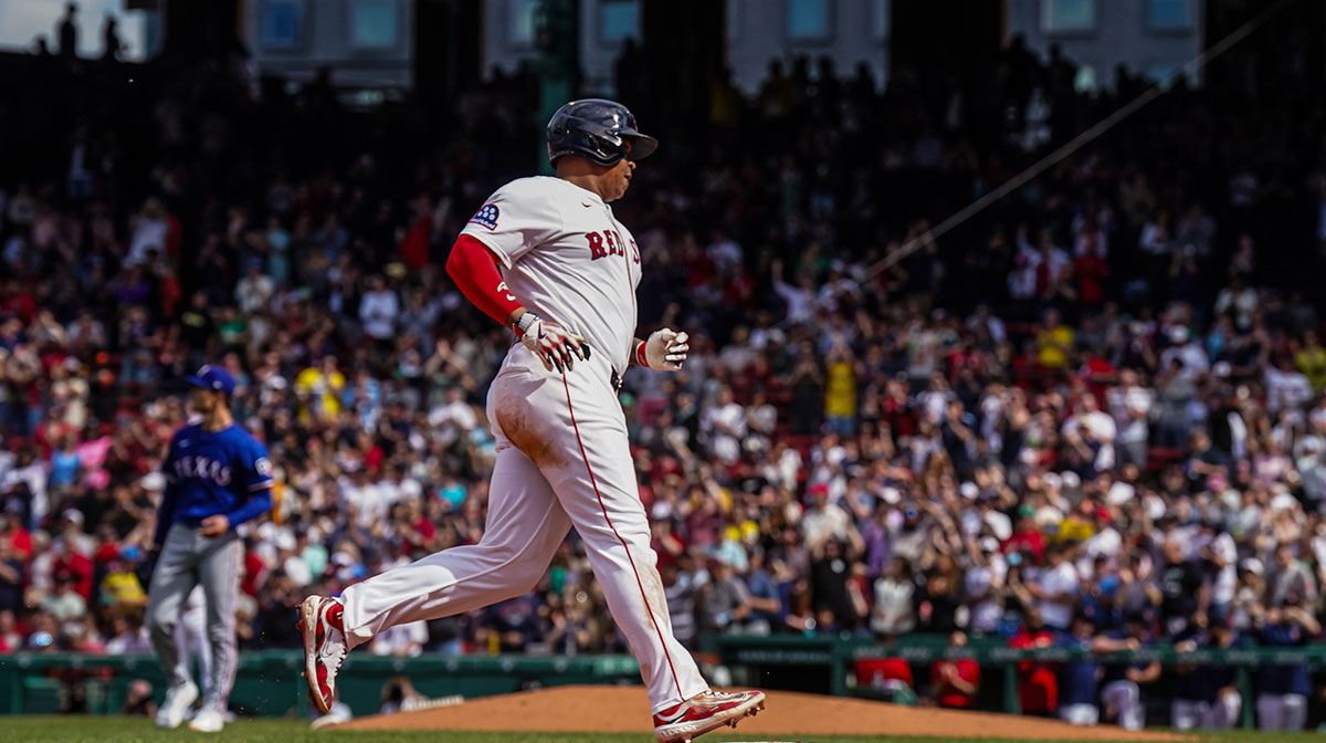 Boston Red Sox designated hitter Rafael Devers (11) hits a home run against the Texas Rangers in the seventh inning at Fenway Park.