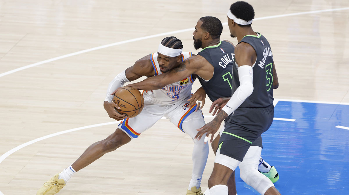 Oklahoma City Thunder guard Shai Gilgeous-Alexander (2) dribbles against Minnesota Timberwolves guard Mike Conley (10) and guard Kevin Porter Jr. (3) in the first quarter during game one of the western conference finals for the 2025 NBA Playoffs at Paycom Center.