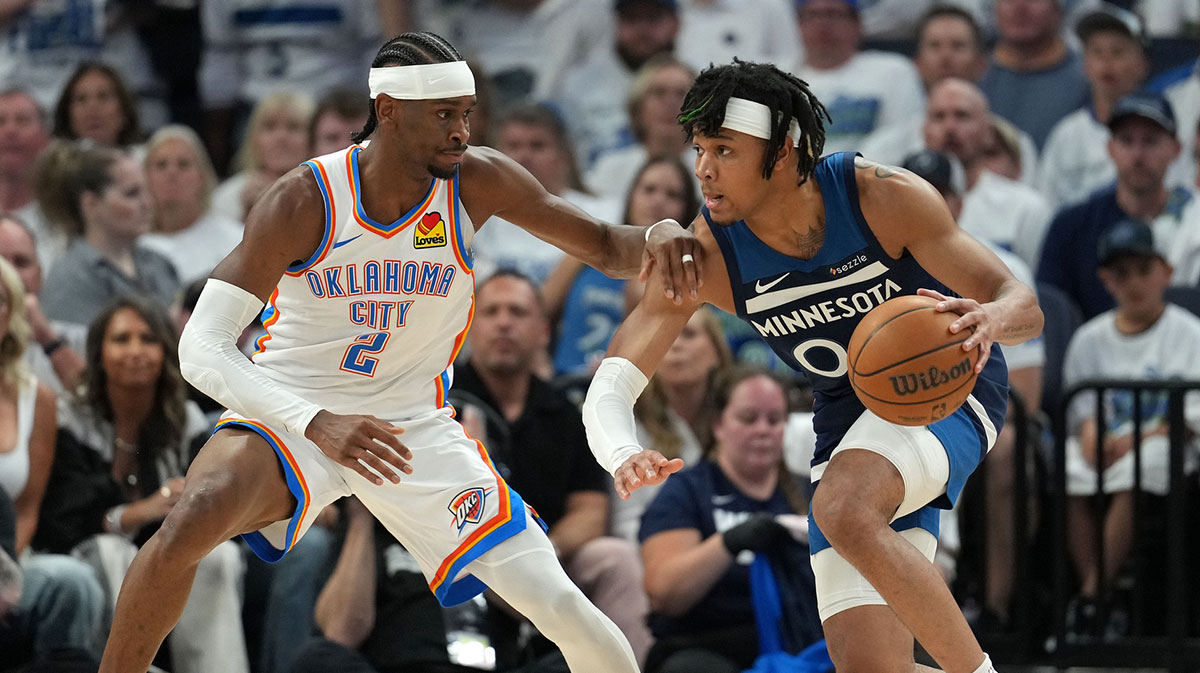 Minnesota Timberwolves guard Terrence Shannon Jr. (00) dribbles the ball against Oklahoma City Thunder guard Shai Gilgeous-Alexander (2) in the first half during game four of the western conference finals for the 2025 NBA Playoffs at Target Center.