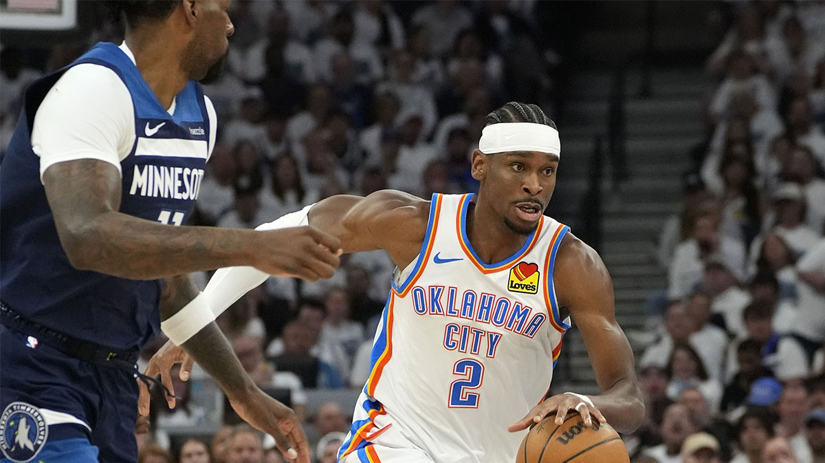 Oklahoma City Thunder guard Shai Gilgeous-Alexander (2) dribbles the ball past Minnesota Timberwolves center Naz Reid (11) in the first half during game four of the western conference finals for the 2025 NBA Playoffs at Target Center.