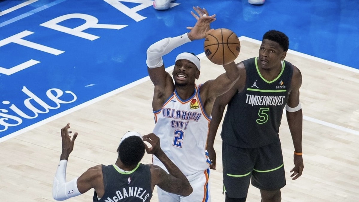 Oklahoma City Thunder guard Shai Gilgeous-Alexander (2) and Minnesota Timberwolves forward Jaden McDaniels (3) fight for a rebound in the fourth quarter during game one of the western conference finals for the 2025 NBA Playoffs at Paycom Center.