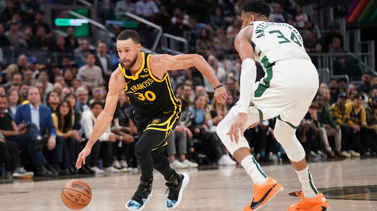 Golden State Warriors guard Stephen Curry (30) dribbles past Milwaukee Bucks forward Giannis Antetokounmpo (34) in the third quarter at the Chase Center.
