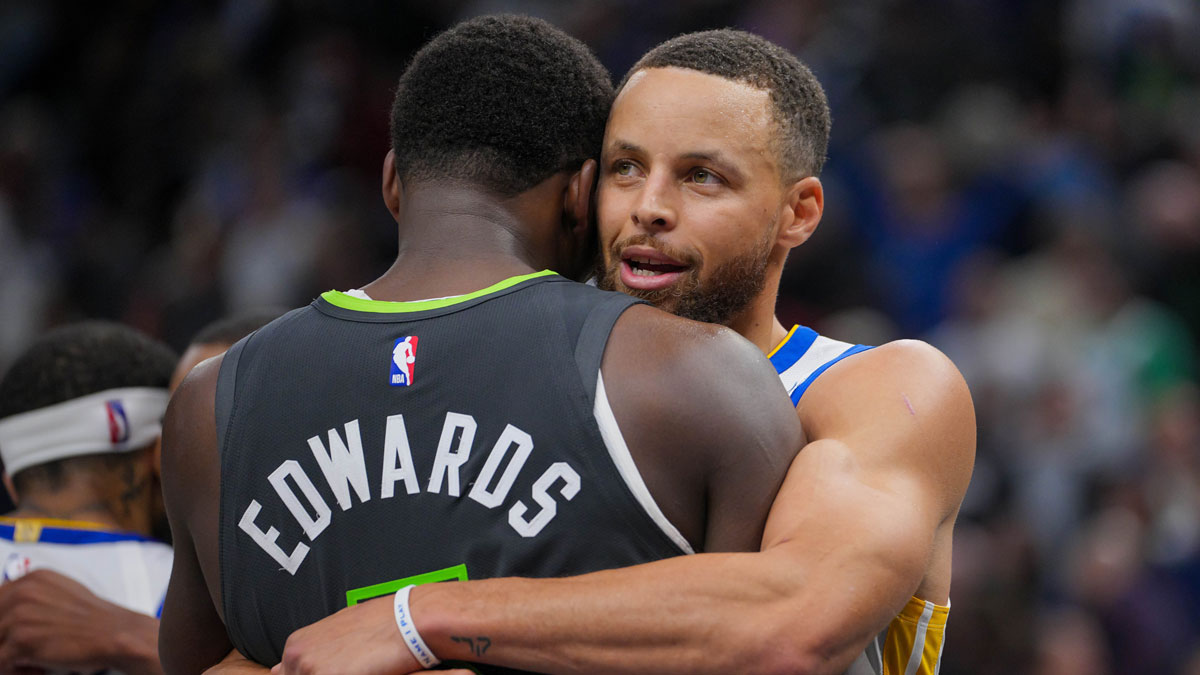 Minnesota Timberwolves guard Anthony Edwards (5) and Golden State Warriors guard Stephen Curry (30) hug after the game at Target Center.