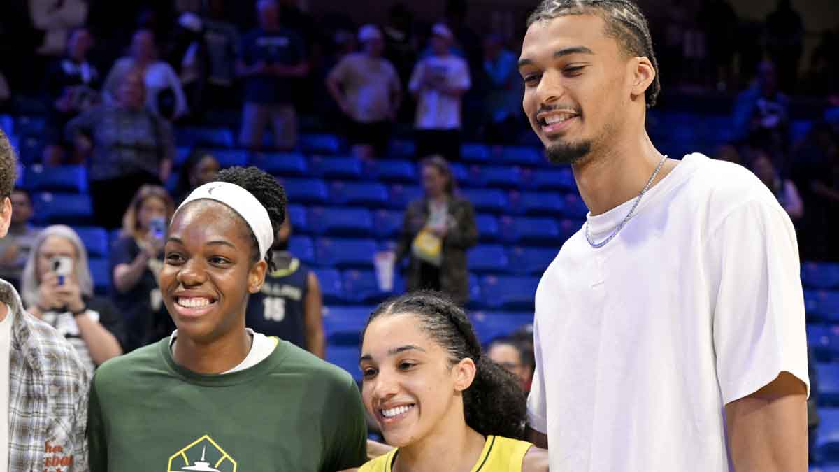 (from left) Seattle Storm center Dominique Malonga and forward Gabby Williams and San Antonio Spurs forward Victor Wembanyama pose for a photo after the game against the Dallas Wings at College Park Center.