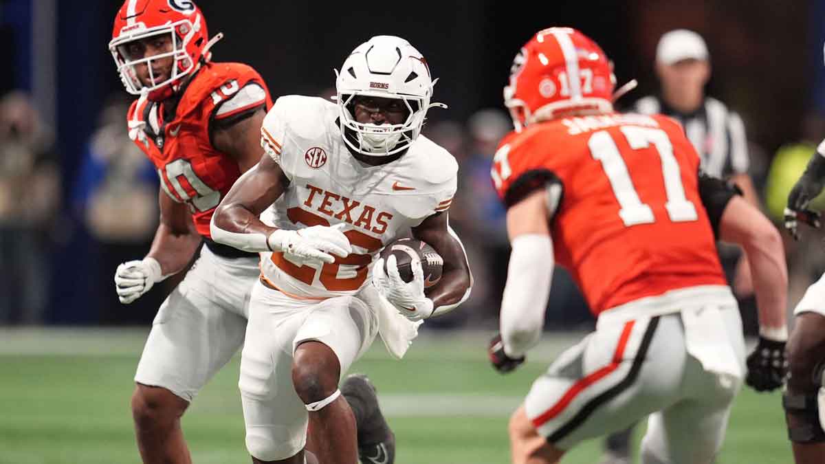 Texas Longhorns running back Quintrevion Wisner (26) rushes the ball against Georgia Bulldogs defensive back Dan Jackson (17) during the first half in the 2024 SEC Championship game at Mercedes-Benz Stadium.