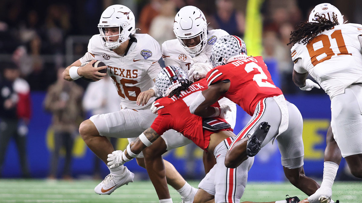 Texas Longhorns quarterback Arch Manning (16) runs against Ohio State Buckeyes cornerback Jordan Hancock (7) and safety Caleb Downs (2) during the second quarter of the College Football Playoff semifinal in the Cotton Bowl at AT&T Stadium.