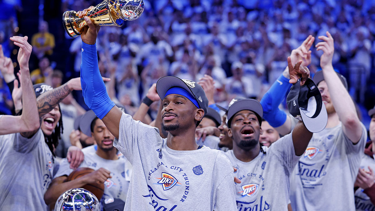 Thunder guard Shai Gilgeous-Alexander (2) celebrates with Magic Johnson West Conference Finals MVP trophy after defeating the Minnesota Timberwolves in game five to win the western conference finals for the 2025 NBA Playoffs at Paycom Center with Paul Pierce in the background