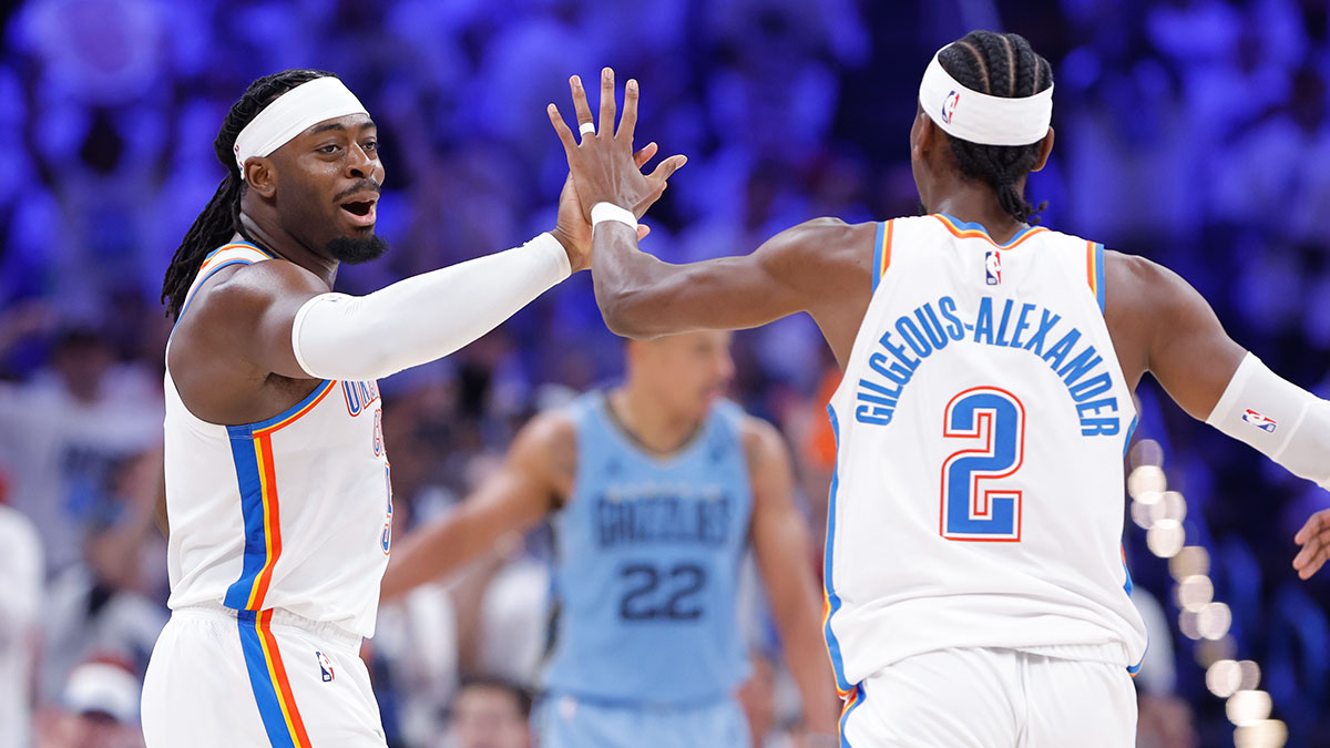 Thunder guard Luguentz Dort (5) high fives guard Shai Gilgeous-Alexander (2) after scoring a three point basket against the Memphis Grizzlies during the second half at Paycom Center