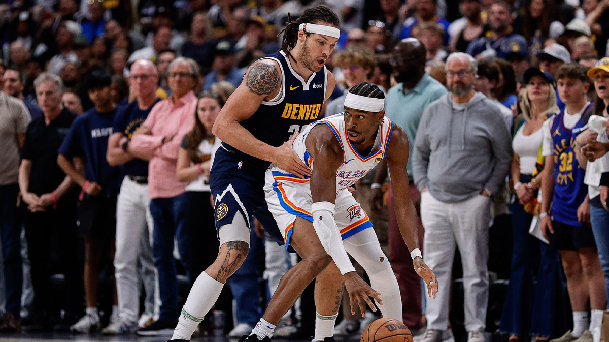 Thunder guard Shai Gilgeous-Alexander (2) controls the ball under pressure from Denver Nuggets forward Aaron Gordon (32) in the fourth quarter during game four of the second round of the 2025 NBA Playoffs at Ball Arena
