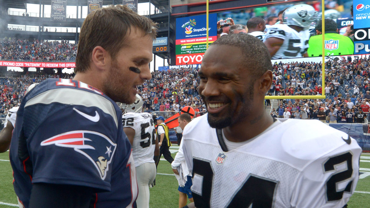 New England Patriots quarterback Tom Brady (12) and Oakland Raiders safety Charles Woodson (24) visit after the game at Gillette Stadium. The Patriots defeated the Raiders 16-9.