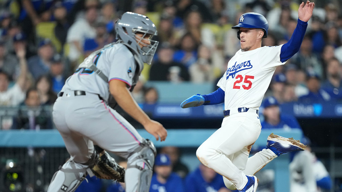 Los Angeles Dodgers second baseman Tommy Edman (25) scores against Miami Marlins catcher Agustin Ramirez (50) during the third inning at Dodger Stadium.