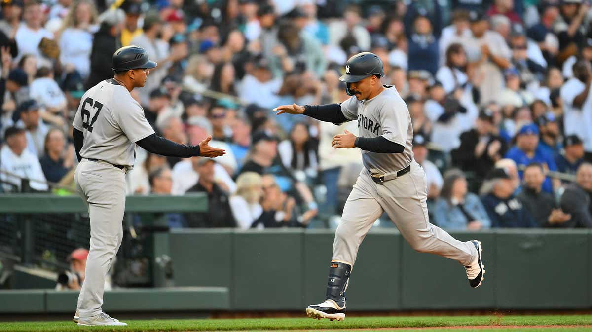 New York Yankees center fielder Trent Grisham (12) celebrates with third base coach Luis Rojas (67) after hittig a home run against the Seattle Mariners during the third inning.