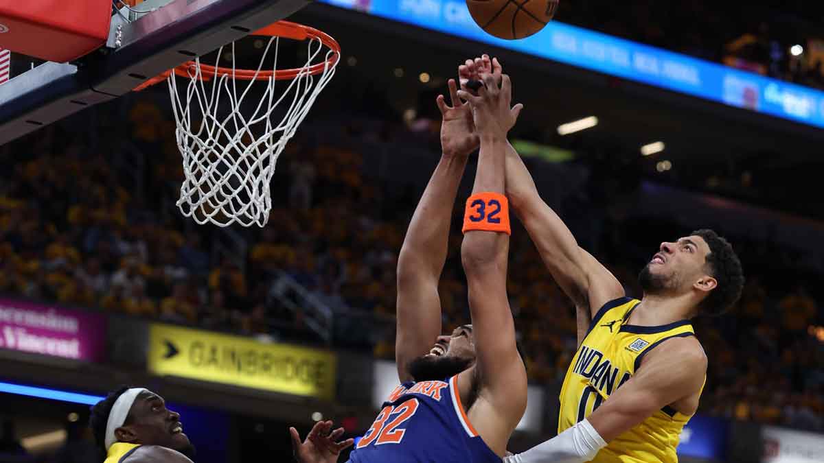 New York Knicks center Karl-Anthony Towns (32), Indiana Pacers guard Tyrese Haliburton (0) and forward Pascal Siakam (43) battle for control of the ball during the third quarter of game four of the eastern conference finals for the 2025 NBA Playoffs at Gainbridge Fieldhouse.