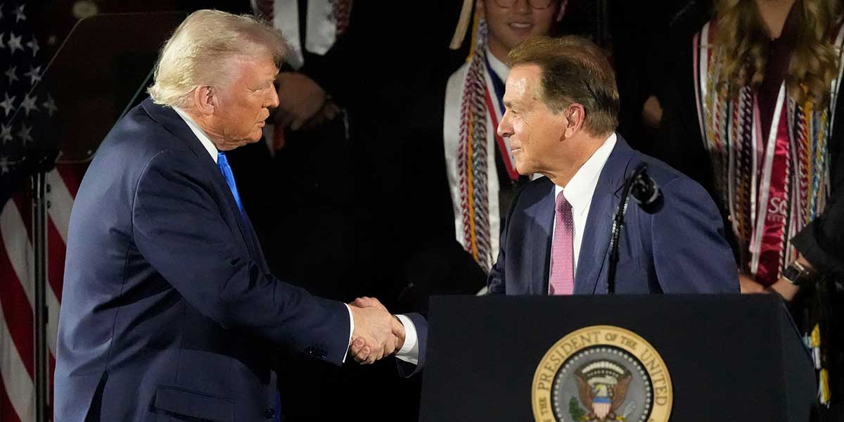 President Donald Trump shakes hands with legendary NCAA Alabama football coach Nick Saban before delivering a special commencement address to University of Alabama graduates at Coleman Coliseum. Graduation occurs over the weekend.