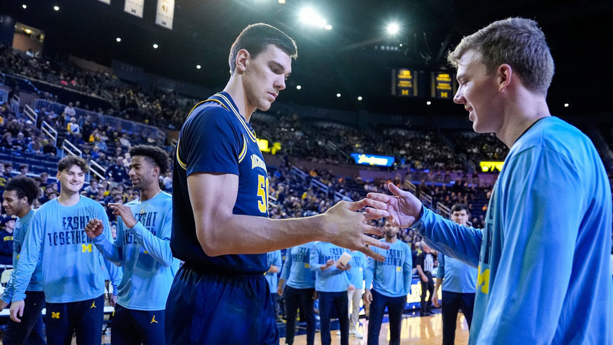 Michigan center Vladislav Goldin (50), center, shakes hands with teammate Charlie May during players introduction before the game between Michigan and Penn State at Crisler Center