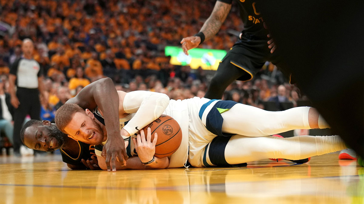 Minnesota Timberwolves guard Donte DiVincenzo (0) gains control of a loose ball next to Golden State Warriors forward Draymond Green (23) in the second quarter during game four of the second round for the 2025 NBA Playoffs at Chase Center.
