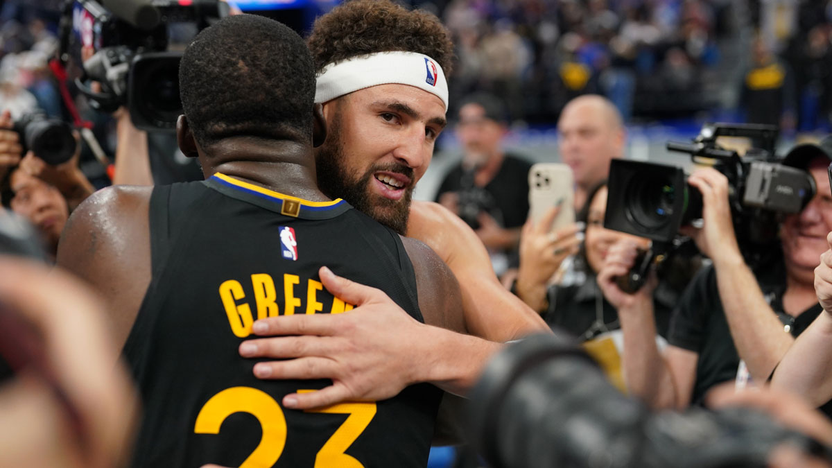 Mavericks guard Klay Thompson (31) hugs Golden State Warriors forward Draymond Green (23) after a game at the Chase Center
