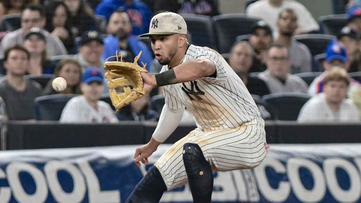 New York Yankees third baseman Oswald Peraza (18) fields a ground ball hit by New York Mets third baseman Mark Vientos (not pictured) and throws to first base for an out during the sixth inning at Yankee Stadium.