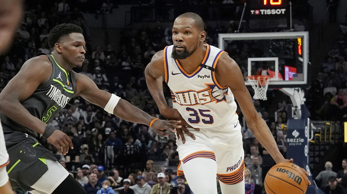 Phoenix Suns forward Kevin Durant (35) brings the ball up as Minnesota Timberwolves guard Anthony Edwards (5) defends him in the fourth quarter at Target Center.
