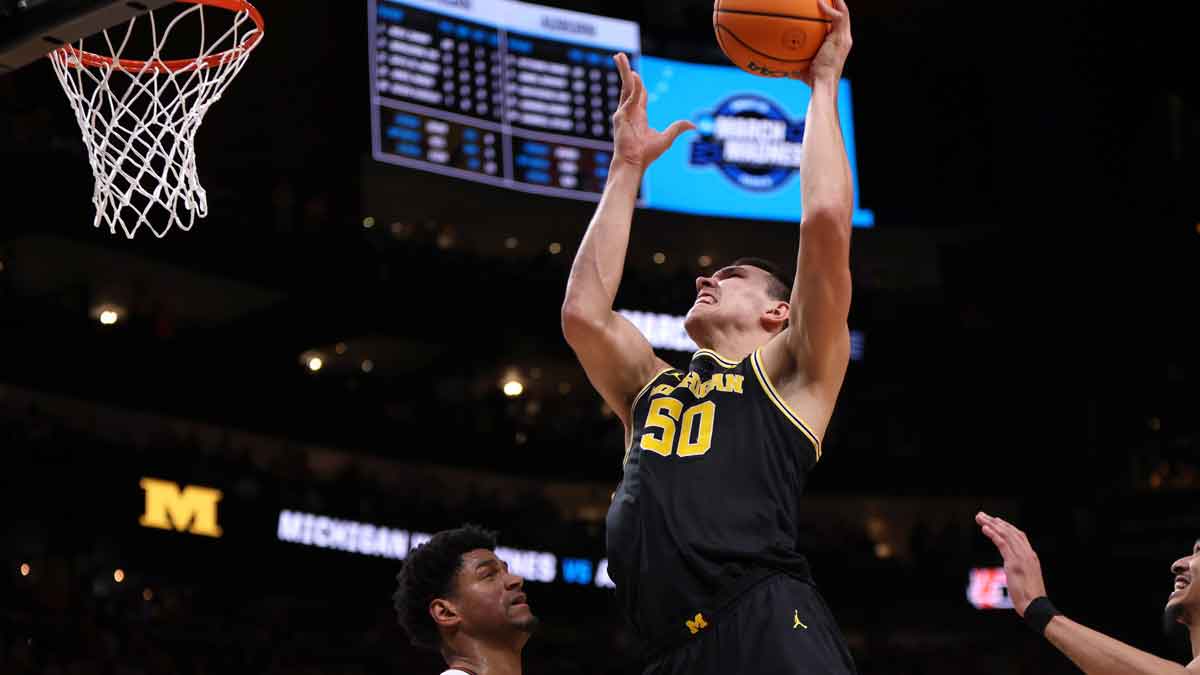 Michigan Wolverines center Vladislav Goldin (50) drives against Auburn Tigers center Dylan Cardwell (44) and guard Chad Baker-Mazara (10) in the second half of a South Regional semifinal of the 2025 NCAA tournament at State Farm Arena.